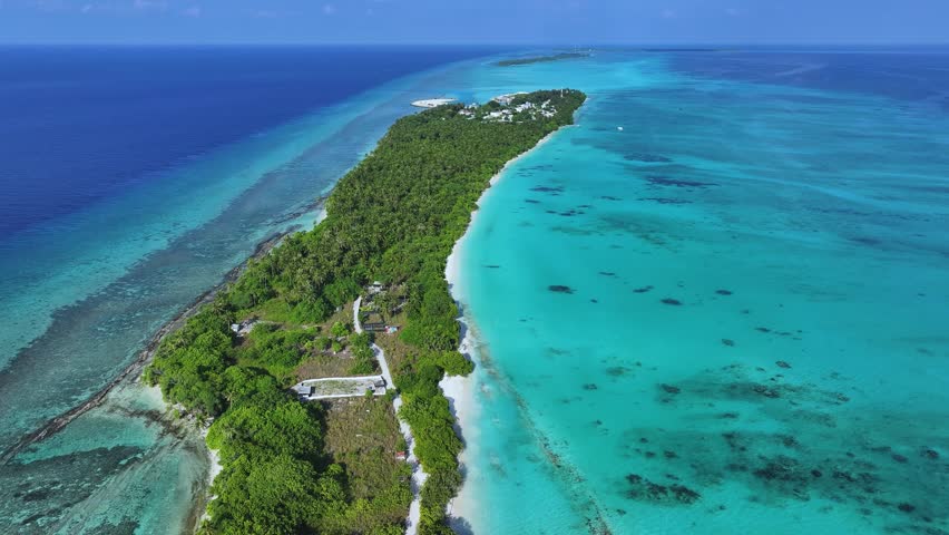 Aerial view of the lush tropical island of Fulhadhoo with white sand beaches and turquoise coral reefs in the Indian Ocean, Fulhadhoo, Baa Atoll, Maldives.