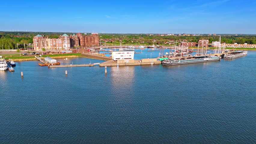 Approaching the port of picturesque Lelystad, the Netherlands on the lake Markermeer. Old ships and modern yachts stand at the berths. Aerial view.