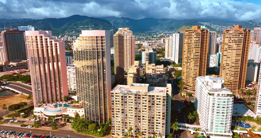 Beautiful diverse high-rise buildings in the cityscape of Honolulu, Hawaii, USA. Dramatic cloudscape covers the mountains at backdrop.