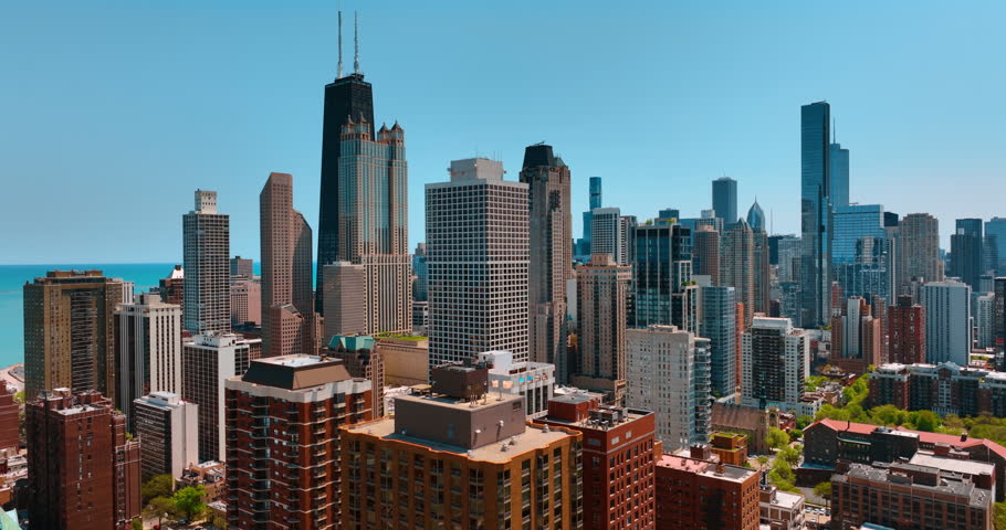 Skyline of stunning modern Chicago, Illinois, USA at the backdrop of blue clear sky. Drone footage rising above the downtown on sunny day.