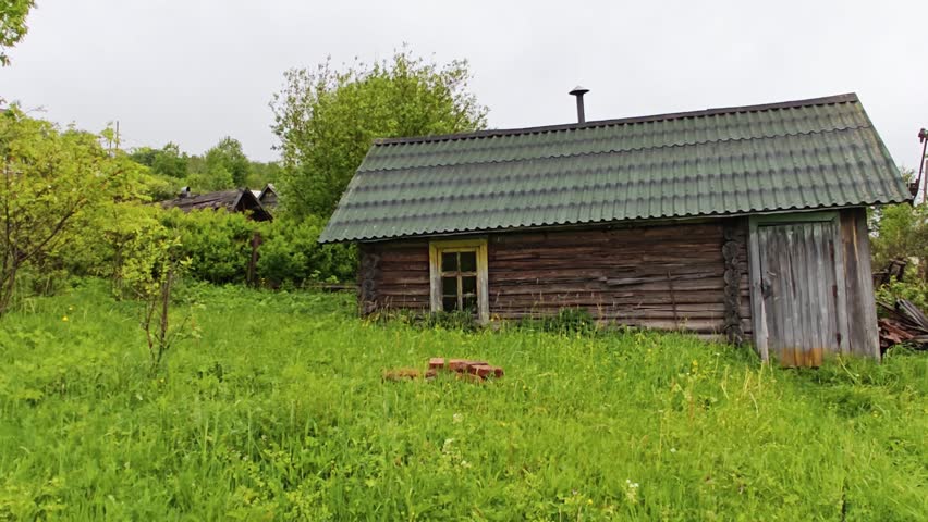 Rustic wooden cabin in a green countryside garden, rural living, simple home, peaceful outdoor lifestyle.