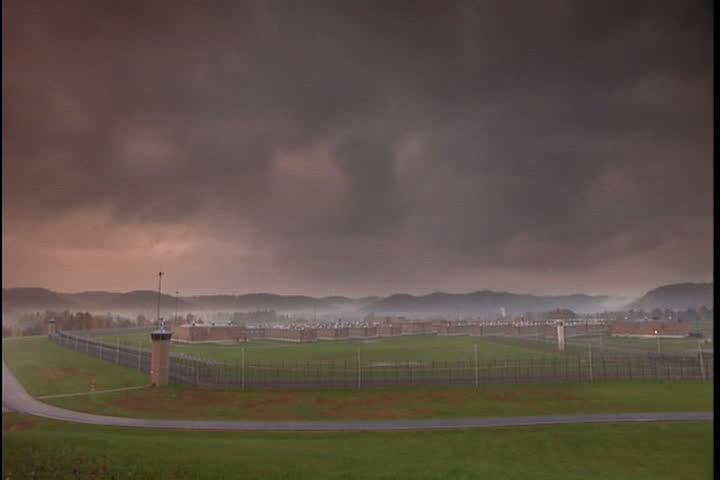 Wide, high angle view of the maximum security Southern Ohio Correctional Facility, with morning mist over mountains, and dark cloudy skyin Lucasville, Ohio
