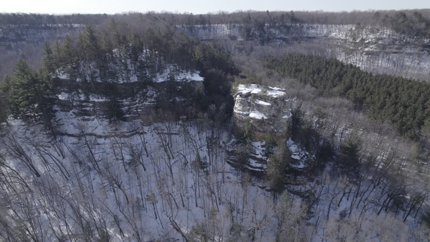 A breathtaking aerial drone video clip flying over the snow-covered bluffs and rugged, unglaciated terrain of the Driftless Area in southwest Wisconsin during a serene winter day.
