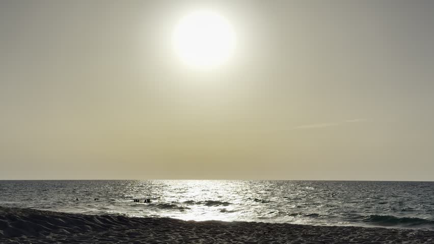 Beautiful cinematic video of a golden sunset over the Mediterranean Sea on the North Coast of Egypt near Alamein, featuring gentle waves, a vibrant orange sky, and sunlight reflecting on the water during the peaceful evening golden hour.