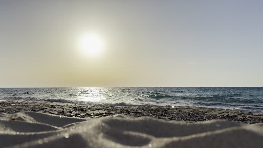 Beautiful cinematic video of a golden sunset over the Mediterranean Sea on the North Coast of Egypt near Alamein, featuring gentle waves, a vibrant orange sky, and sunlight reflecting on the water during the peaceful evening golden hour.