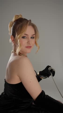 Glamorous blonde in a black velvet dress posing. Glamorous woman concept