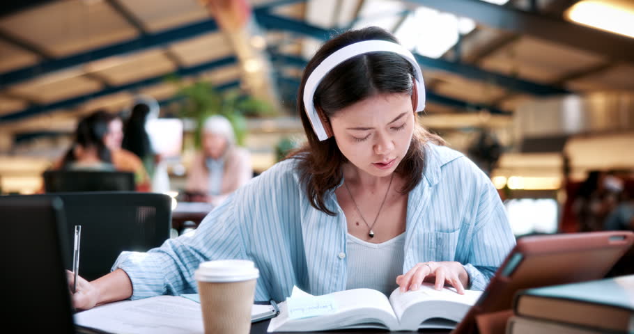 Woman, student and reading with headphones in university study for education, learning or knowledge. Female person, learner or writing with audio app or textbooks for language translation or research