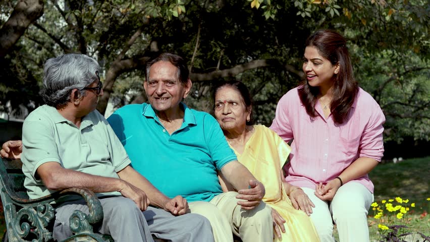 Happy Indian multi generation family sitting together on a park bench. Concept of bonding, love, care, and family support.