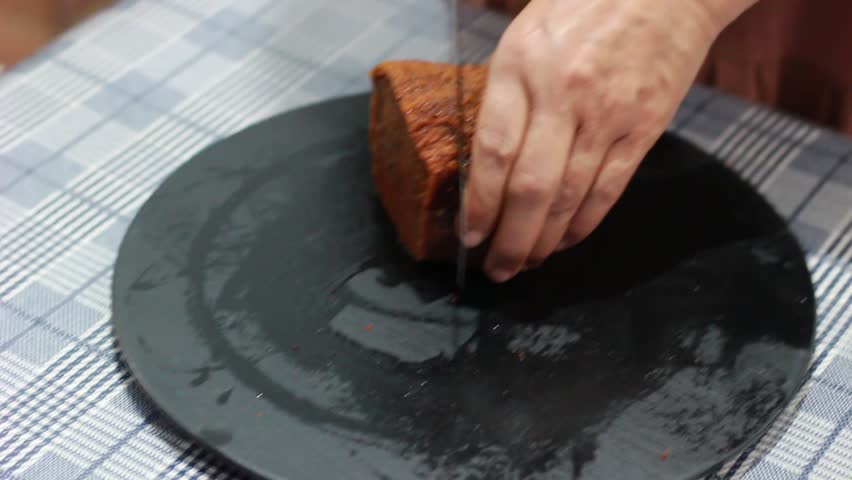 Temanggung, Indonesia - June 4, 2026 : brown caramel bread being sliced ​​with a knife on a plate