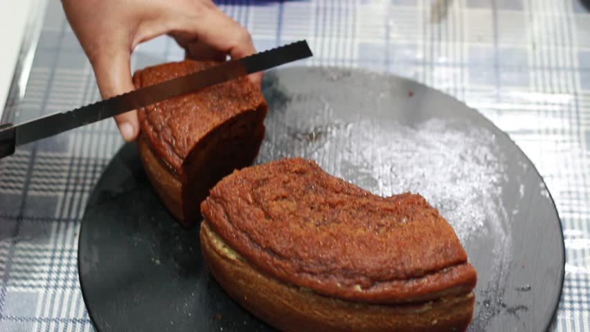 Temanggung, Indonesia - June 4, 2026 : brown caramel bread being sliced ​​with a knife on a plate