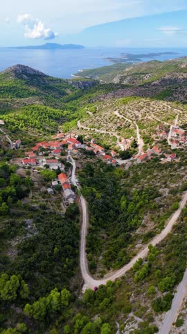 Idyllic aerial perspective of the historic village of velo grablje, nestled among green hills on hvar island with the adriatic sea in the background