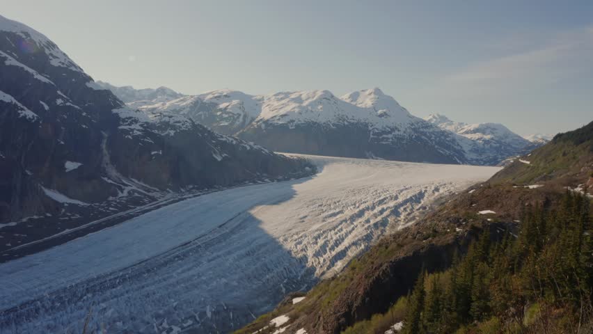 Salmon Glacier flowing through mountains, surrounded by snow and ice in British Columbia, Canada