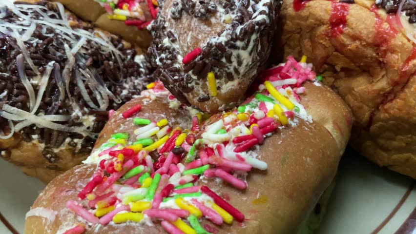 assorted chocolate donuts on a plate isolated on a black background