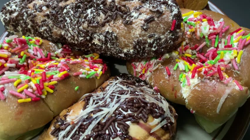 assorted chocolate donuts on a plate isolated on a black background