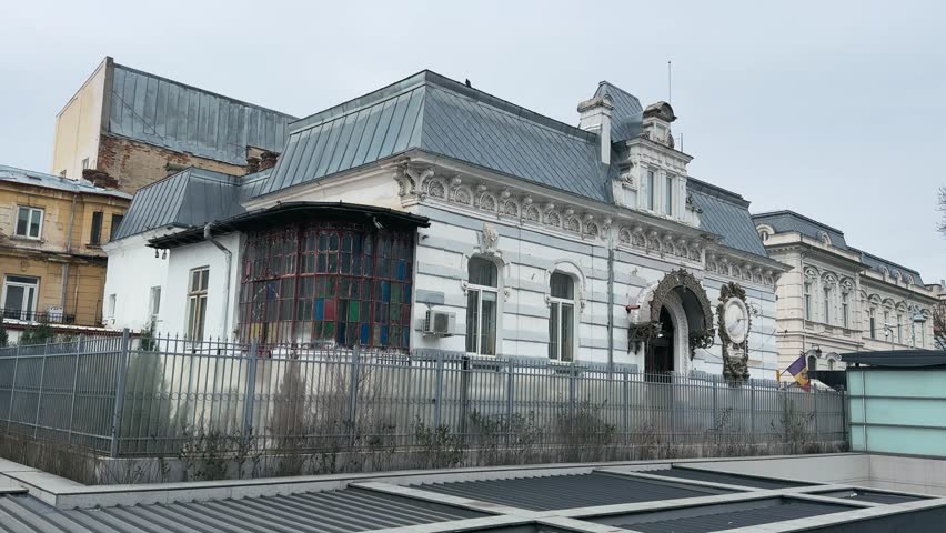 Exterior shot of the Art Safari Museum in Bucharest, Romania. Ornate architectural details and a distinctive grey roof are visible under an overcast sky, reflecting authentic local heritage and design.