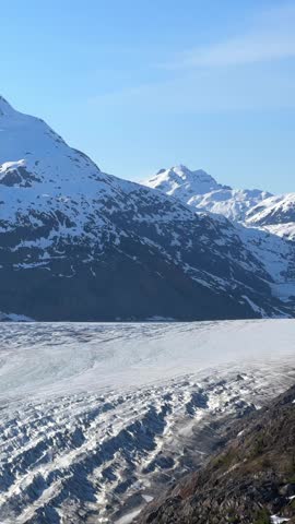 Salmon Glacier flowing through mountains, surrounded by snow and ice in British Columbia, Canada