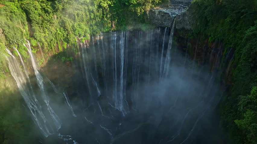 Aerial view of Panorama Tumpak Sewu Waterfalls also known as Coban Sewu.Beautiful rainbow and fog,Tumpak Sewu Waterfalls are a tourist attraction in East Java, Indonesia.Amazing travel destination