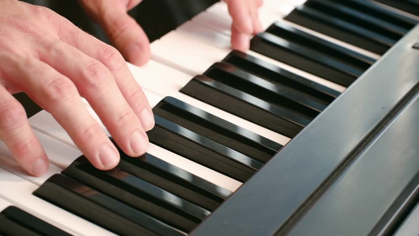 Close up musician hands playing beautiful melody on digital piano keyboard, showcasing musical talent and artistic expression in graceful performance. Male hands playing piano keyboard music