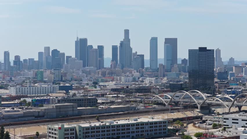 High angle of Los Angeles skyline revealing downtown skyscrapers, Arts District, historic Sixth Street Viaduct, highlighting urban sprawl and infrastructure