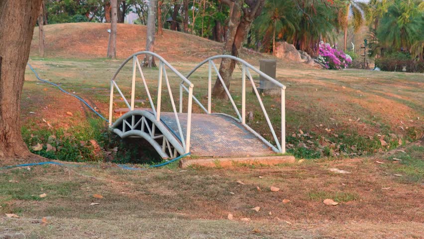 A white metal bridge structure in a park