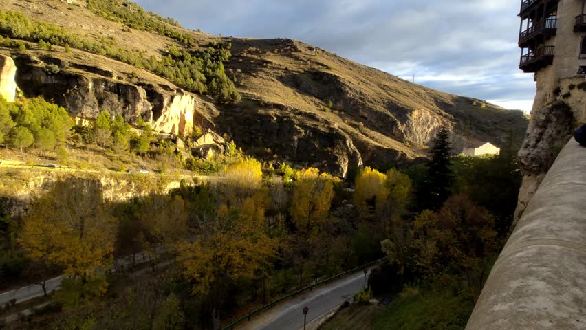 View of Casas Colgadas balconies with hillside monument in late afternoon sunlight