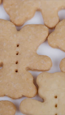 Homemade cookies display. Cookies resembling bears scattered across surface. Softly lit closeup of homemade bear cookies with rustic charm and natural textures