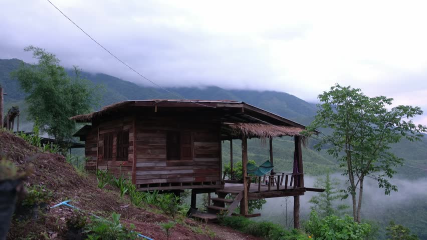 Wooden house in the mountains on foggy morning