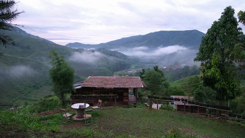 A wooden cabin in the mountains on foggy morning
