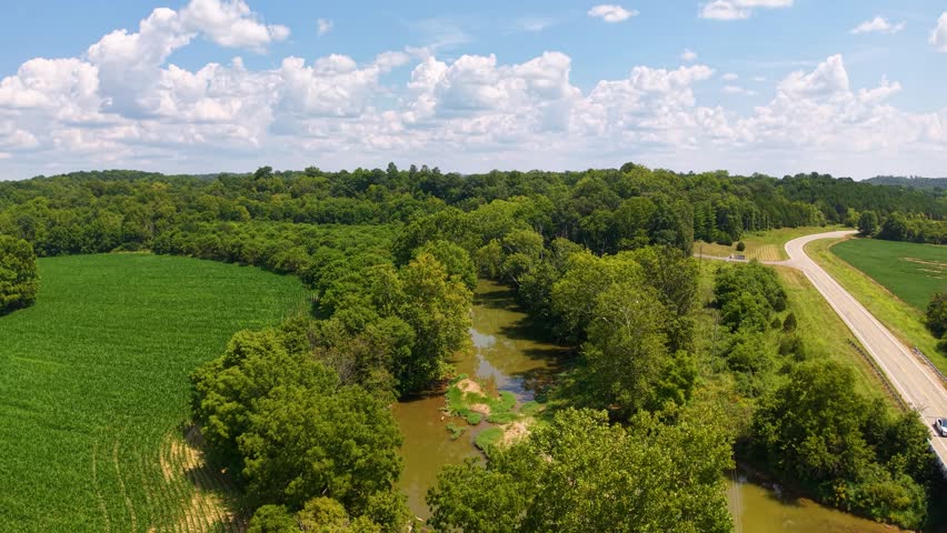 Aerial view of a nature reserve with rivers and wooded areas under a partly cloudy sky.