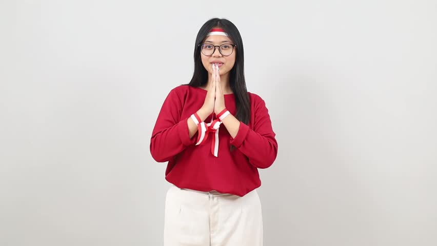 Young Pretty Indonesian woman making Namaste greeting gesture with Indonesia Independence day concept