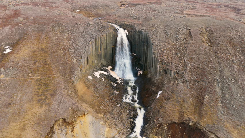 Aerial view of a waterfall Studlafoss flowing through a rocky canyon