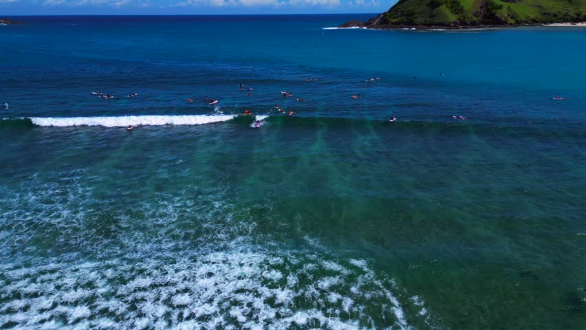 Surfer riding a blue ocean wave on a sunny day. Perfect aerial view drone