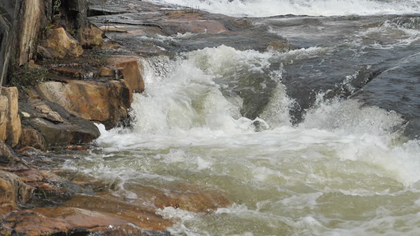 The waterfall has a rapid flow and splashes of water.