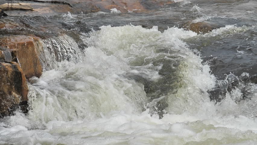 The waterfall has a rapid flow and splashes of water.