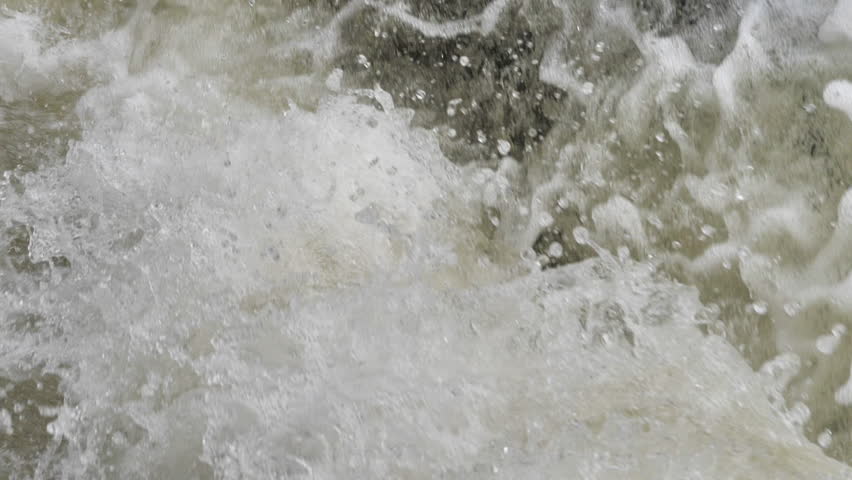 The waterfall has a rapid flow and splashes of water.