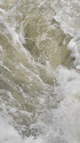 The waterfall has a rapid flow and splashes of water.
