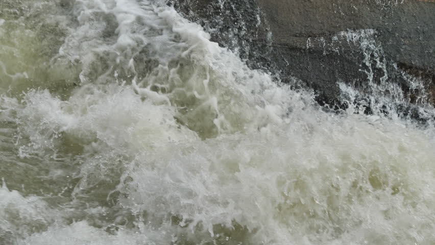 The waterfall has a rapid flow and splashes of water.
