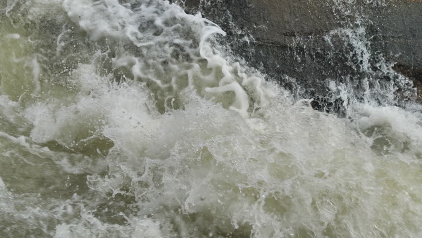 The waterfall has a rapid flow and splashes of water.