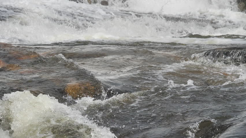 The waterfall has a rapid flow and splashes of water.
