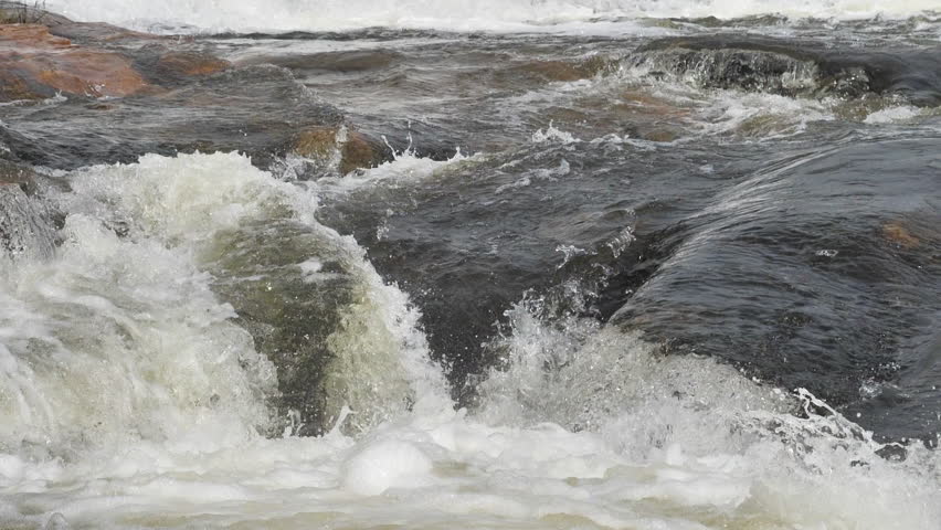 The waterfall has a rapid flow and splashes of water.