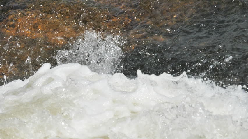 The waterfall has a rapid flow and splashes of water.