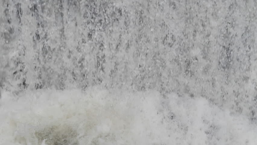 The waterfall has a rapid flow and splashes of water.