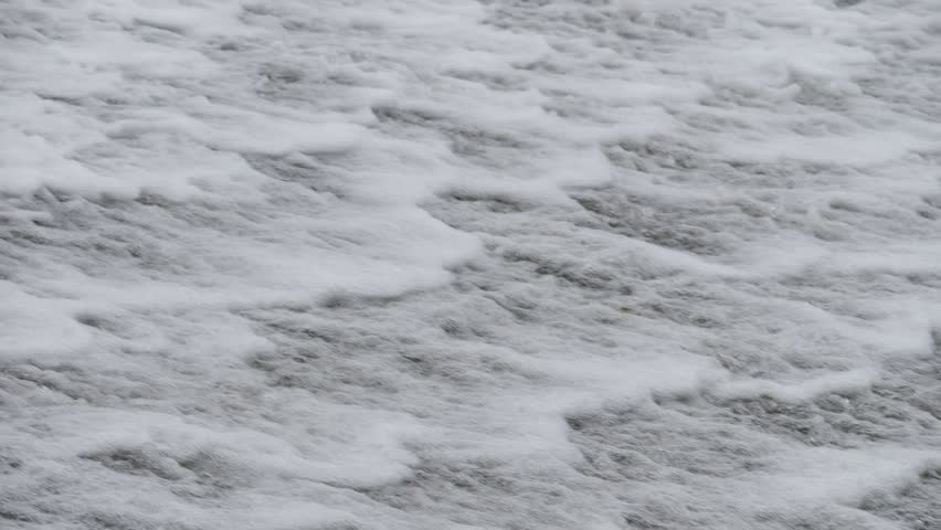 The waterfall has a rapid flow and splashes of water.
