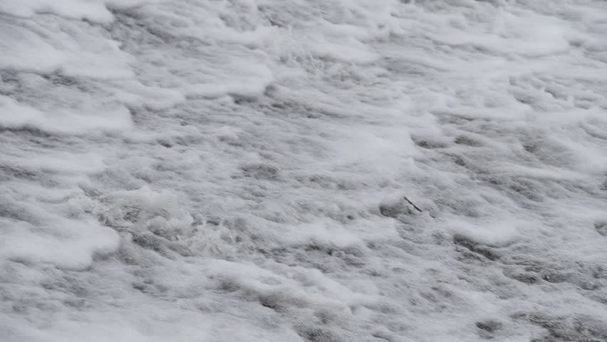 The waterfall has a rapid flow and splashes of water.