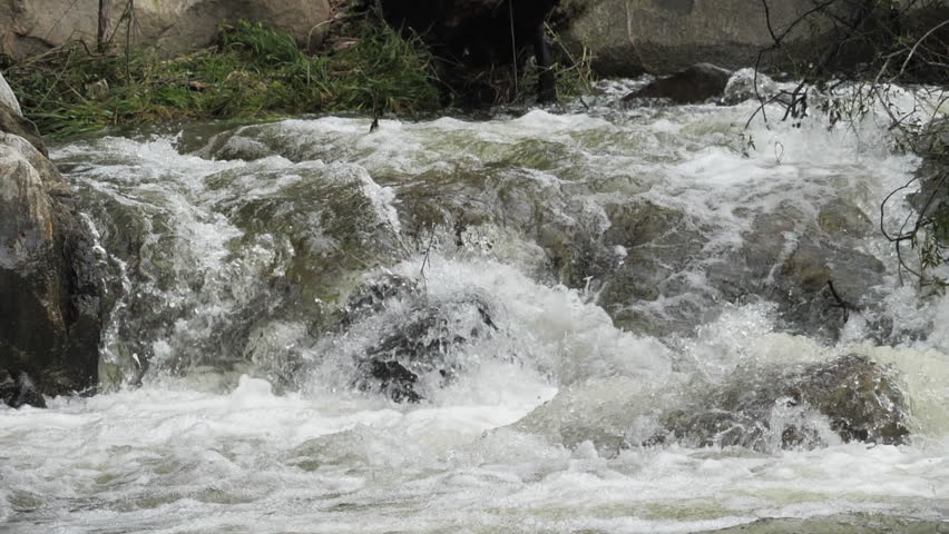 The waterfall has a rapid flow and splashes of water.