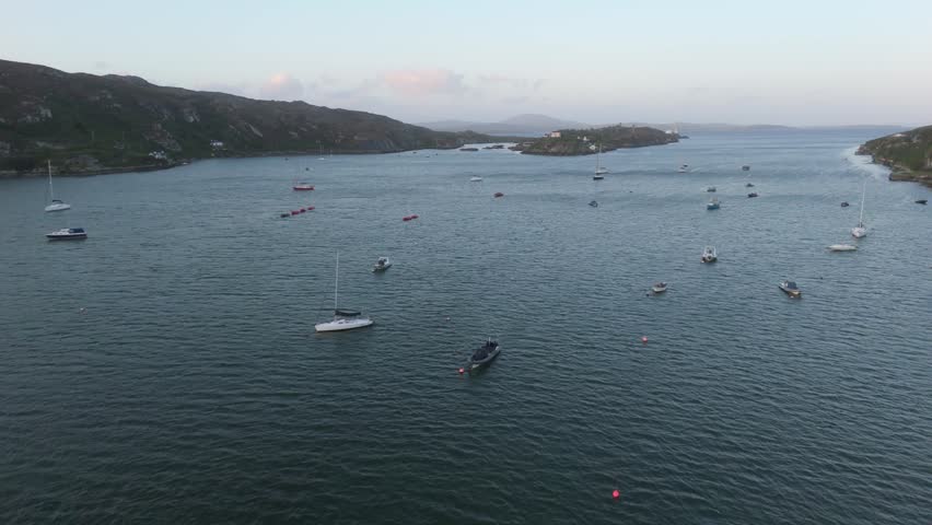 Serene bay dotted with various boats under a soft sky.
