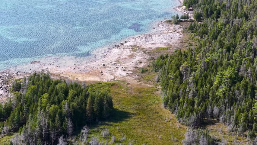 Aerial view of wilderness near Hessel, Michigan with Lake Huron bordering forested areas.
