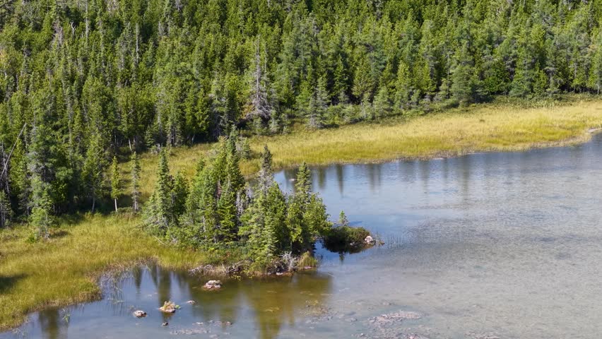 Aerial view of a serene lake with forested islands in Hessel, Michigan near Lake Huron.
