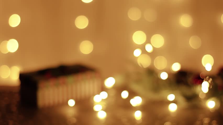 Happy couple clink glasses of champagne toast and celebrate together New year at home, standing against the background of glowing Christmas lights bright bokeh background, close-up hand view.