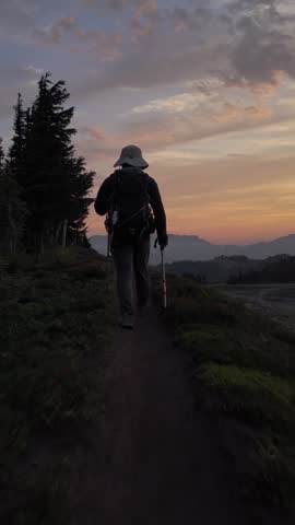 Adventurous Hiker Explores a Scenic Mountain Trail in British Columbia, Canada, During a Vibrant Sunset